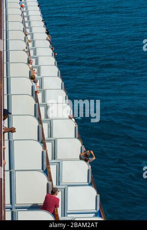 Urlauber, die auf einem Kreuzfahrtschiff von ihrer Kabinenterrasse aus den Ozean sehen Stockfoto
