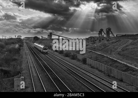 2 erste Transpennine Express-Klasse 185 passiert die stillgelegte Zeche Hatfield mit den Kopfbeständen und den dunklen Wolken Stockfoto