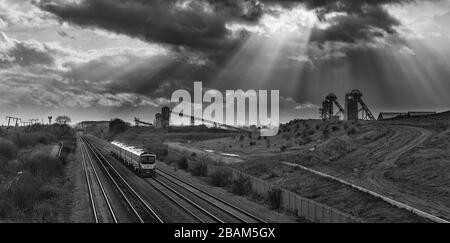 2 erste Transpennine Express-Klasse 185 passiert die stillgelegte Zeche Hatfield mit den Kopfbeständen und den dunklen Wolken Stockfoto