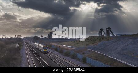 2 erste Transpennine Express-Klasse 185 passiert die stillgelegte Zeche Hatfield mit den Kopfbeständen und den dunklen Wolken Stockfoto