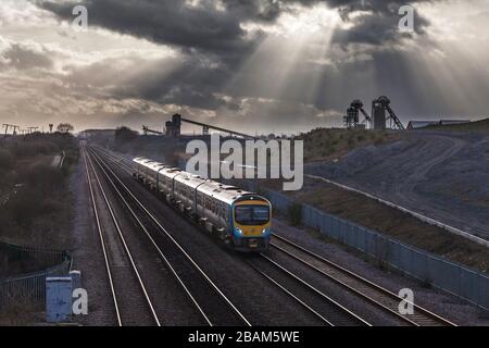 2 erste Transpennine Express-Klasse 185 passiert die stillgelegte Zeche Hatfield mit den Kopfbeständen und den dunklen Wolken Stockfoto