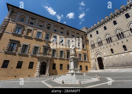 Die Statue von Sallustio Bandini auf der Piazza Salimbeni mit Rocca Salimbeni auf der rechten Seite und Palazzo Tantucci auf der linken Seite in Siena, Italien Stockfoto