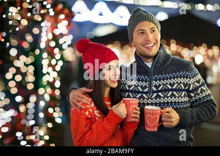 Junge Paare, Die Sich Zu Weihnachten Im Freien Vergnügen Stockfoto
