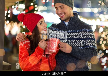 Junge Paare, Die Sich Zu Weihnachten Im Freien Vergnügen Stockfoto