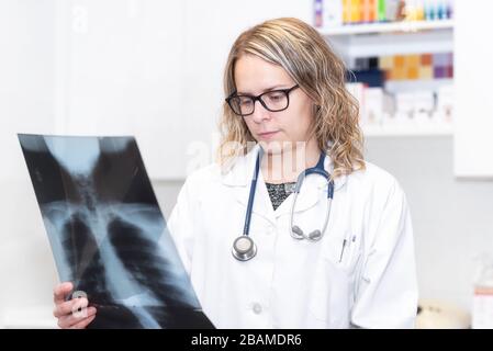 Covid-19. Weiblicher Arzt mit Röntgenaufnahme der Lunge eines Patienten. Konzept zur Erkennung von Lungenerkrankungen, Diagnose von Pneumonie und Coronoviren . Stockfoto