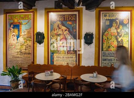 Innenbereich Bodego-Bar El Pimpi. Feria oder faire Plakate aus dem frühen 20. Jahrhundert. Málaga, Costa del Sol, Provinz Málaga, Andalusien, Südspanien. Stockfoto