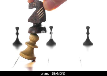 Schachkonzept mit Mann in Bewegung. Hand, die schwarzen Schachknecht auf Schachbrett hält. Stockfoto