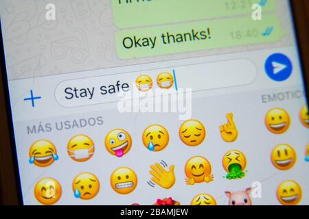 Coronavirus Covid19 Bleiben Sie sicher SMS auf dem Handy mit maskierten Emojis Emoticons. SMS an Freunde/Verwandte senden. Bleiben Sie zu Hause gesperrt Stockfoto
