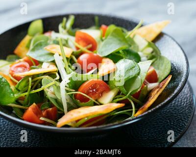 Wintersalat mit Zucchini, Tomaten, Zwiebeln und gerösteten Tortillas. Stockfoto