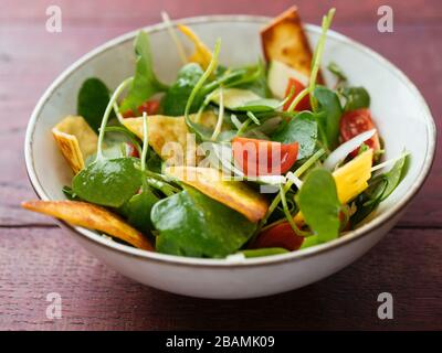 Wintersalat mit Zucchini, Tomaten, Zwiebeln und gerösteten Tortillas. Stockfoto