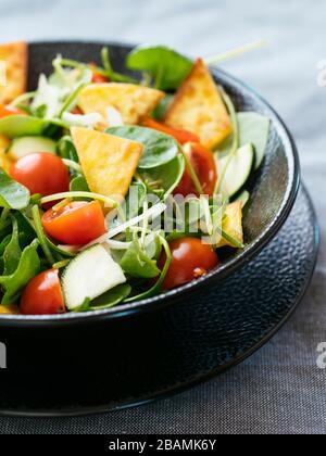 Wintersalat mit Zucchini, Tomaten, Zwiebeln und gerösteten Tortillas. Stockfoto