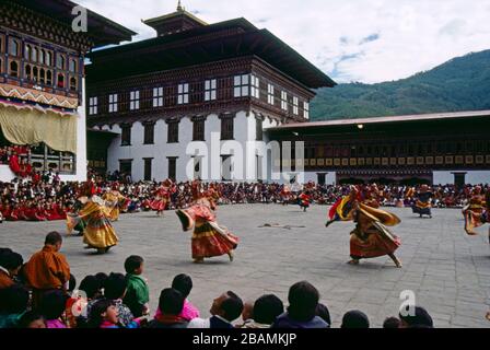 Tänzerinnen beim jährlichen Thimphu, Bhutan Tsechu Festival wirbeln und stürzen sich, während sie auf dem offenen Platz des Dzong-Tempels tanzen. (12-10-89) BX54 Stockfoto