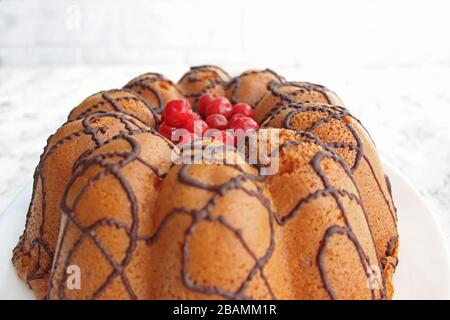 Hausgemachter Kuchen mit Beeren und Schokoladenvereisung. Sehr süßer Kuchen. Dessertkonzept. Dunkler und heller Hintergrund Stockfoto