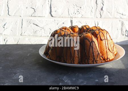 Ein selbstgebackener Kuchen wird von der Sonne angezündet. Am frühen Morgen. Frühstück. Hausgemachtes Backen mit Schokolade Stockfoto