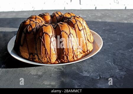 Ein selbstgebackener Kuchen wird von der Sonne angezündet. Am frühen Morgen. Frühstück. Hausgemachtes Backen mit Schokolade Stockfoto