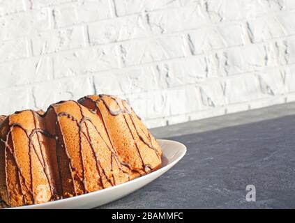 Ein selbstgebackener Kuchen wird von der Sonne angezündet. Am frühen Morgen. Frühstück. Hausgemachtes Backen mit Schokolade Stockfoto