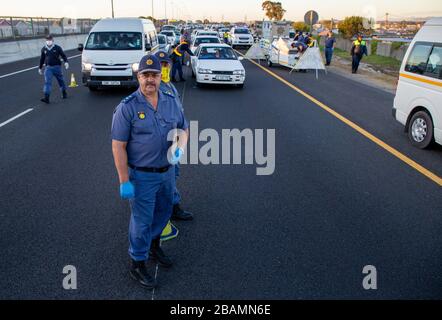 KAPSTADT, SÜDAFRIKA - Samstag, 28. März 2020: Major-General Vincent Beaton vom südafrikanischen Polizeidienst und Mitglieder der südafrikanischen nationalen Verteidigungsstreitkräfte setzen an einer Straßensperre auf der vielbefahrenen Autobahn R300 ein, nachdem die südafrikanische Regierung im Rahmen der Erklärung des Staates der nationalen Katastrophe von Präsident Cyril eine 21-tägige COVID-19-Sperre erklärt hatte Ramaphosa. Das Gesundheitsministerium hat die Bewohner aufgefordert, die Vorschriften zu beachten, Hygiene zu üben, zu Hause zu bleiben und soziale Distanzierungen zu praktizieren. Foto von Roger Sedres Stockfoto