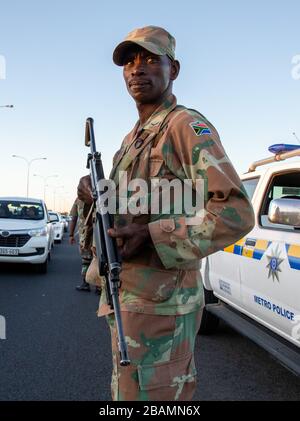 KAPSTADT, SÜDAFRIKA - Samstag, 28. März 2020: Mitglieder des South African Police Service und der South African National Defence Force stationieren an einer Straßensperre auf der vielbefahrenen Autobahn R300, nachdem die südafrikanische Regierung eine 21-tägige COVID-19-Sperre als Teil der Erklärung des Staates der nationalen Katastrophe durch Präsident Cyril Ramaphosa ausgerufen hatte. Das Gesundheitsministerium hat die Bewohner aufgefordert, die Vorschriften zu beachten, Hygiene zu üben, zu Hause zu bleiben und soziale Distanzierungen zu praktizieren. Foto von Roger Sedres Stockfoto