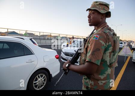 KAPSTADT, SÜDAFRIKA - Samstag, 28. März 2020: Mitglieder des South African Police Service und der South African National Defence Force stationieren an einer Straßensperre auf der vielbefahrenen Autobahn R300, nachdem die südafrikanische Regierung eine 21-tägige COVID-19-Sperre als Teil der Erklärung des Staates der nationalen Katastrophe durch Präsident Cyril Ramaphosa ausgerufen hatte. Das Gesundheitsministerium hat die Bewohner aufgefordert, die Vorschriften zu beachten, Hygiene zu üben, zu Hause zu bleiben und soziale Distanzierungen zu praktizieren. Foto von Roger Sedres Stockfoto