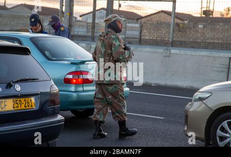 KAPSTADT, SÜDAFRIKA - Samstag, 28. März 2020: Mitglieder des South African Police Service und der South African National Defence Force stationieren an einer Straßensperre auf der vielbefahrenen Autobahn R300, nachdem die südafrikanische Regierung eine 21-tägige COVID-19-Sperre als Teil der Erklärung des Staates der nationalen Katastrophe durch Präsident Cyril Ramaphosa ausgerufen hatte. Das Gesundheitsministerium hat die Bewohner aufgefordert, die Vorschriften zu beachten, Hygiene zu üben, zu Hause zu bleiben und soziale Distanzierungen zu praktizieren. Foto von Roger Sedres Stockfoto