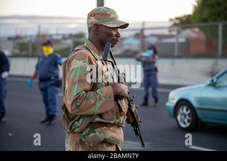 KAPSTADT, SÜDAFRIKA - Samstag, 28. März 2020: Mitglieder des South African Police Service und der South African National Defence Force stationieren an einer Straßensperre auf der vielbefahrenen Autobahn R300, nachdem die südafrikanische Regierung eine 21-tägige COVID-19-Sperre als Teil der Erklärung des Staates der nationalen Katastrophe durch Präsident Cyril Ramaphosa ausgerufen hatte. Das Gesundheitsministerium hat die Bewohner aufgefordert, die Vorschriften zu beachten, Hygiene zu üben, zu Hause zu bleiben und soziale Distanzierungen zu praktizieren. Foto von Roger Sedres Stockfoto