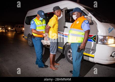 KAPSTADT, SÜDAFRIKA - Samstag, 28. März 2020: Ein Taxifahrer wird an einer Straßensperre in Khayelitsha von Verkehrsbeamten aus der Stadt Kapstadt verhaftet, nachdem die südafrikanische Regierung im Rahmen der Erklärung des US-Präsidenten Cyril Ramaphosa eine 21-tägige COVID-19-Sperre erklärt hatte. Das Gesundheitsministerium hat die Bewohner aufgefordert, die Vorschriften zu beachten, Hygiene zu üben, zu Hause zu bleiben und soziale Distanzierungen zu praktizieren. Foto von Roger Sedres Stockfoto