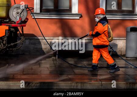 Moskau, Russland. Am 28. März 2020 VERWENDET EIN Straßenreiniger einen Wasserstrahlwaschgang mit Desinfektionsmitteln, um das Straßenpflaster im Zentrum Moskaus während der Coronavirus COVID-19-Pandemie in Russland zu reinigen. Straßen und andere öffentliche Bereiche werden gereinigt und desinfiziert, um der Verbreitung des neuartigen Coronavirus entgegenzuwirken. Stockfoto