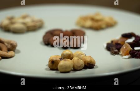 Verschiedene Arten von Nüssen in weißen Mandeln, Pistachios, Cashews, Erdnuss, Haselnuss, Trockenfrüchte Stockfoto