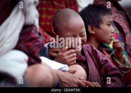 Ein junger, bhutanischer Junge genießt die Gings auf Bhutans jährlichem Thimphu Tsechu. Stockfoto