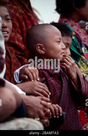 Ein junger, bhutanischer Junge genießt die Gings auf Bhutans jährlichem Thimphu Tsechu. Stockfoto