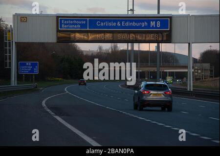 Glasgow, Großbritannien. März 2020. Abgebildet: Straßenschilder auf den Autobahnen M8 und M80, die lauten: "BLEIBEN SIE ZU HAUSE RETTEN SIE LEBEN" die Pandemie von Coronavirus hat die britische Regierung gezwungen, eine Abschaltung aller britischen Großstädte anzuordnen und die Menschen zu Hause zu lassen. Das hat die Autobahnen und alle anderen Straßen frei von der üblichen Nase gelassen, um den Verkehr, der sonst da wäre, zu vereitelen. Kredit: Colin Fisher/Alamy Live News Stockfoto