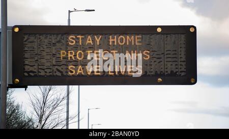 Glasgow, Großbritannien. März 2020. Abgebildet: Straßenschilder auf den Autobahnen M8 und M80, die lauten: "BLEIBEN SIE ZU HAUSE SCHÜTZEN Sie NHS RETTEN SIE LEBEN" die Pandemie von Coronavirus hat die britische Regierung gezwungen, eine Abschaltung aller britischen Großstädte anzuordnen und die Menschen zu Hause zu lassen. Das hat die Autobahnen und alle anderen Straßen frei von der üblichen Nase gelassen, um den Verkehr, der sonst da wäre, zu vereitelen. Kredit: Colin Fisher/Alamy Live News Stockfoto