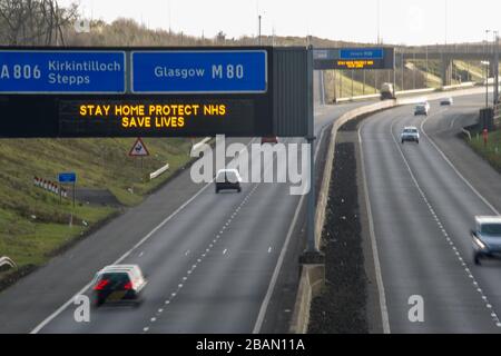 Glasgow, Großbritannien. März 2020. Abgebildet: Straßenschilder auf den Autobahnen M8 und M80, die lauten: "BLEIBEN SIE ZU HAUSE SCHÜTZEN Sie NHS RETTEN SIE LEBEN" die Pandemie von Coronavirus hat die britische Regierung gezwungen, eine Abschaltung aller britischen Großstädte anzuordnen und die Menschen zu Hause zu lassen. Das hat die Autobahnen und alle anderen Straßen frei von der üblichen Nase gelassen, um den Verkehr, der sonst da wäre, zu vereitelen. Kredit: Colin Fisher/Alamy Live News Stockfoto