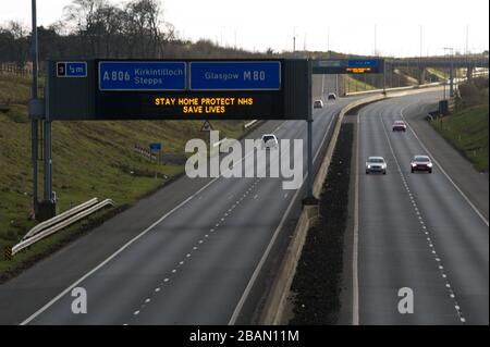 Glasgow, Großbritannien. März 2020. Abgebildet: Straßenschilder auf den Autobahnen M8 und M80, die lauten: "BLEIBEN SIE ZU HAUSE SCHÜTZEN Sie NHS RETTEN SIE LEBEN" die Pandemie von Coronavirus hat die britische Regierung gezwungen, eine Abschaltung aller britischen Großstädte anzuordnen und die Menschen zu Hause zu lassen. Das hat die Autobahnen und alle anderen Straßen frei von der üblichen Nase gelassen, um den Verkehr, der sonst da wäre, zu vereitelen. Kredit: Colin Fisher/Alamy Live News Stockfoto