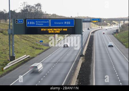 Glasgow, Großbritannien. März 2020. Abgebildet: Straßenschilder auf den Autobahnen M8 und M80, die lauten: "BLEIBEN SIE ZU HAUSE SCHÜTZEN Sie NHS RETTEN SIE LEBEN" die Pandemie von Coronavirus hat die britische Regierung gezwungen, eine Abschaltung aller britischen Großstädte anzuordnen und die Menschen zu Hause zu lassen. Das hat die Autobahnen und alle anderen Straßen frei von der üblichen Nase gelassen, um den Verkehr, der sonst da wäre, zu vereitelen. Kredit: Colin Fisher/Alamy Live News Stockfoto