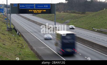 Glasgow, Großbritannien. März 2020. Abgebildet: Straßenschilder auf den Autobahnen M8 und M80, die lauten: "BLEIBEN SIE ZU HAUSE SCHÜTZEN Sie NHS RETTEN SIE LEBEN" die Pandemie von Coronavirus hat die britische Regierung gezwungen, eine Abschaltung aller britischen Großstädte anzuordnen und die Menschen zu Hause zu lassen. Das hat die Autobahnen und alle anderen Straßen frei von der üblichen Nase gelassen, um den Verkehr, der sonst da wäre, zu vereitelen. Kredit: Colin Fisher/Alamy Live News Stockfoto