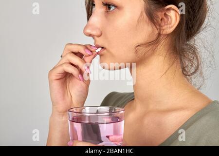 Junges Mädchen, das Pille zur Heilung der Grippe nimmt. Stockfoto