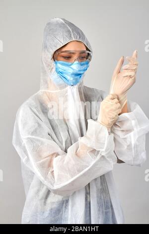 Junge Frau mit Atemmaske und weißen medizinischen Gummihandschuhen. Stockfoto