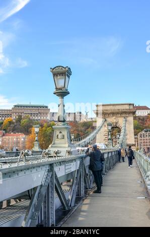 Budapest, Ungarn - 6. November 2019: Berühmte Szechenyi-Kettenbrücke, Hängebrücke, über die Donau in der ungarischen Hauptstadt. Touristen Sehenswürdigkeiten. Buda-Burg im Hintergrund. Vertikales Foto. Stockfoto