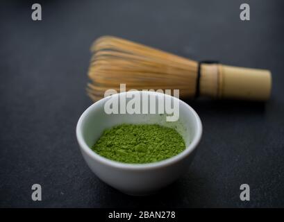 matcha grünes Teepulver und Bambuswisk auf Schiefergrund Stockfoto