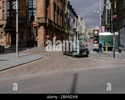 Sehen Sie sich eine menschenleere Buchanan Street mit einem einzigen Taxi an, das an einem normalerweise geschäftigen Samstag in Glasgow während der britischen Coronavirus Pandemie wartet. Stockfoto