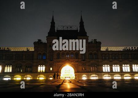 Moskau, Russland. März 2020. Die Menschen laufen am GUMMI auf dem Roten Platz vorbei, während der Veranstaltung "Earth Hour" am 28. März 2020 in Moskau, Russland. Credit: Evgeny Sinitsyn/Xinhua/Alamy Live News Stockfoto