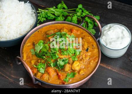 Geröstete Auberginen mit geräuchertem Cardamom und Kokosnussmilch: Curry aus Auberginen mit Minze und Cilantro mit Basmati-Reis und Joghurt in der Stockfoto