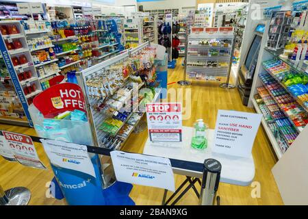 Coronavirus Warnschilder und Händewaschanlagen am Eingang einer Amcal Apotheke am internationalen Abflugterminal des Flughafens Sydney (Kingsford Smith) in Australien. Der Chemiker hatte die Barriere und Warnungen am Ladeneingang platziert, um Flugpassagiere, die gerade nach Australien gekommen waren, zu bitten, sich an "soziale Distanzierungsregeln" zu halten, um das Risiko einer Verbreitung des Coronavirus zu verringern. Stockfoto