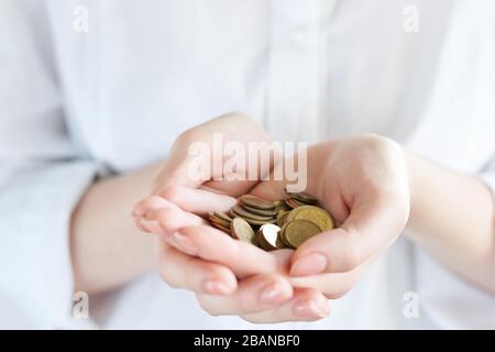 Eine Handvoll Münzen in Palmenhand isoliert von der weißen Wirtschaftskrise. Sparen Sie Geld. Helfen Sie anderen Menschen Stockfoto