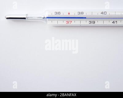 Nahaufnahme eines Thermometers zur Messung der Körpertemperatur Grad Celsius bei 38,5 Hintergrund. Stockfoto