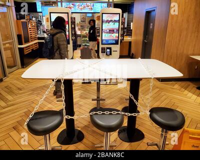 Montreal, Kanada - 22. März 2020: Verkettete Sitze und Tische in McDonalds aufgrund von Coronavirus. Viele Restaurants und Fastfood-Plätze legen Kette auf Tische Stockfoto