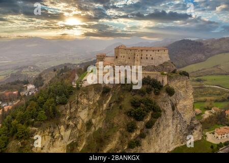 Luftaufnahme der Stadt und Festung San Leo, die einst als Gefängnis auf einem Felsvorsprung in der Nähe des Badeortes Rimini und San Marino mit römischer Kirche genutzt wurde Stockfoto