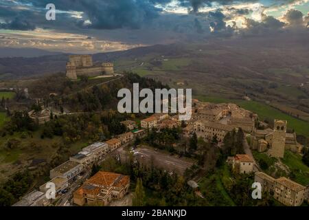 Luftaufnahme der Stadt und Festung San Leo, die einst als Gefängnis auf einem Felsvorsprung in der Nähe des Badeortes Rimini und San Marino mit römischer Kirche genutzt wurde Stockfoto