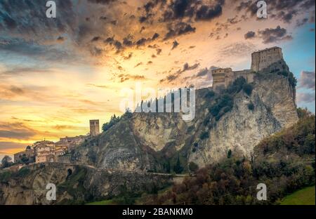 Blick auf die Festung San Leo bei Sonnenuntergang auf einem Hügel mit Kanonentürmen in Italien Stockfoto